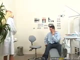 Adembenemend tiener rondborstig blondine dentist shows haar boezem naar een patiënt