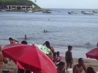 Casal trepando na praia.